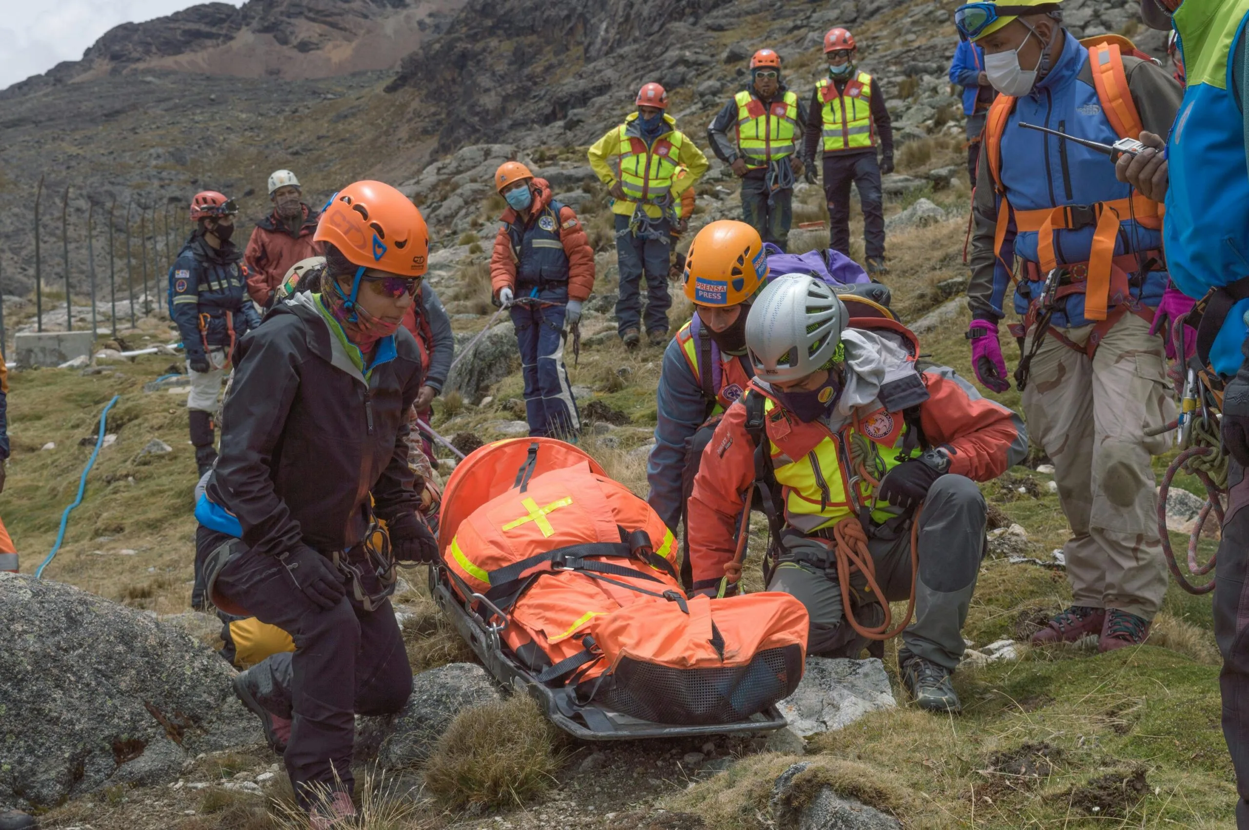 Rescue team performs mountain rescue using a stretcher to aid an injured hiker.